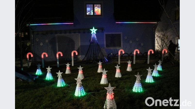 Im Garten leuchten Zuckerstangen und Sternkegel, im oberen Stockwerk läuft ein Weihnachtsfilm. Es wirkt, als ob der Weihnachtsmann mit seinen Wichteln in der Werkstatt arbeitet und den Schlitten belädt - und das alles zu Hause bei Familie Schertler. Bild: rpp