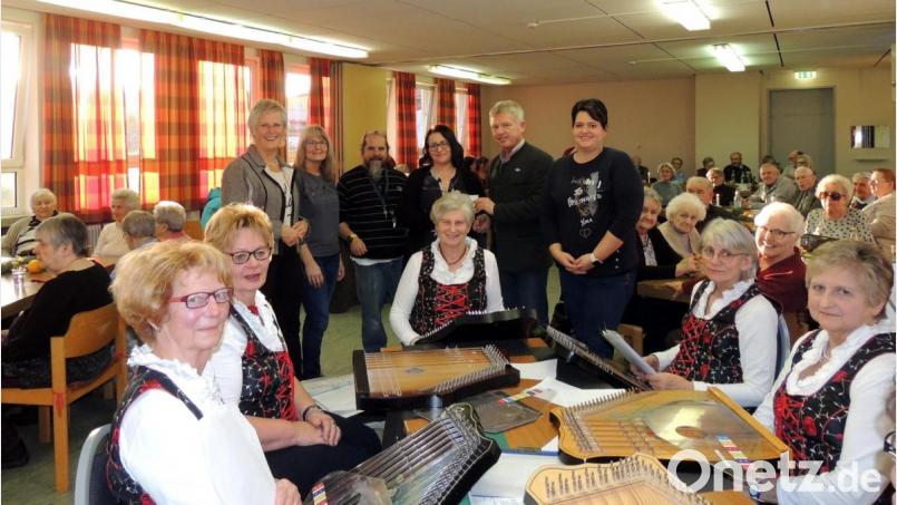 Die Grafenwöhrer Unions-Familie überreicht 200 Euro an Nadine Brüderer und Robert Heldmann (Zweite und Dritter, stehend rechts) von der Caritas-Betreuungsgruppe &quot;Arche&quot;. Die &quot;Vorbacher Saiten&quot; (im Vordergrund) umrahmen die Weihnachtsfeier musikalisch. Bild: exb
