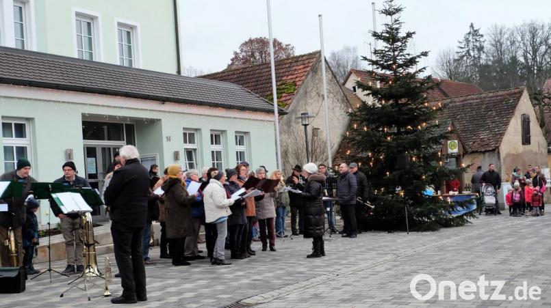 Auf Weihnachten stimmen Posaunenchor, Gesangverein und Blaskapelle die zahlreich zum Weihnachtssingen am Rathaus gekommenen Zuhörer ein. Bild: wlr