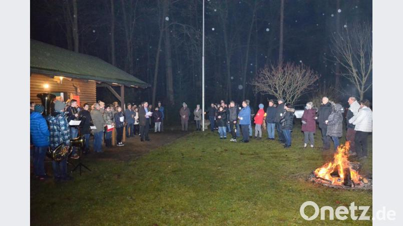 Bläser- und Gesangsgruppe bereichern die OWV-Waldweihnacht mit Stadtpfarrer Hans Ring auf der Lichtung vor der eigenen Waldhütte. Bild: fjo
