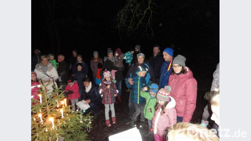 Gespannt lauschen die Kinder rings um den mit Kerzen, Glöckchen und Nüssen geschmückten Baum der Geschichte vom kleinen Tannenbaum. Bild: jhö