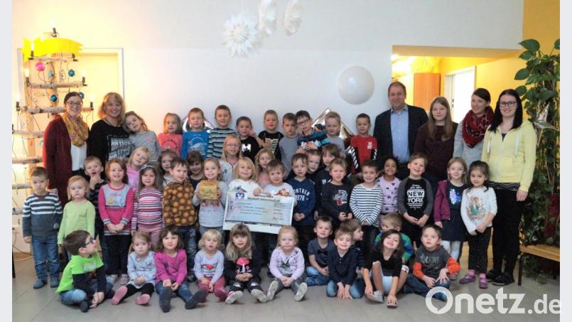 Kita-Elternbeiratsvorsitzende Andrea Graf (links) übergibt zusammen mit den Mädchen und Buben der Kita die "erbackenen" 500 Euro an den Leiter des SOS-Kinderdorfes Immenreuth, Holger Hassel (Vierter von rechts). Bild: fvo