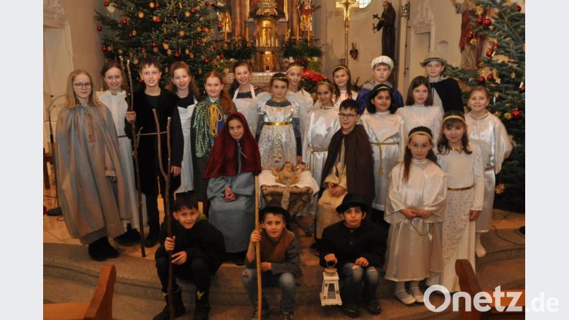 Eine große Gruppe an Kindern studierte das Krippenspiel in der St. Erhard Kirche in Roggenstein ein und trugen es mustergültig vor. Andächtig stehen sie vor der Krippe des Jesuskinds. Bild: dob