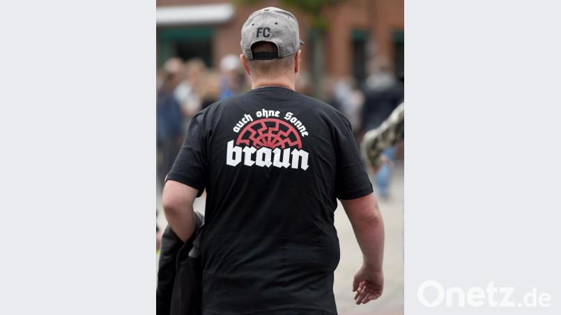 Ein Teilnehmer einer rechten Kundgebung trägt ein T-Shirt mit einer Rune in Form einer halben &quot;schwarzen Sonne&quot; die einem Hakenkreuz ähnelt. Eine schwarze Sonne, Erkennungssymbol der rechtsextremen Szene, trägt CDU-Kreispolitiker Robert Möritz als Tattoo auf der Haut. Bild: Caroline Seidel/dpa