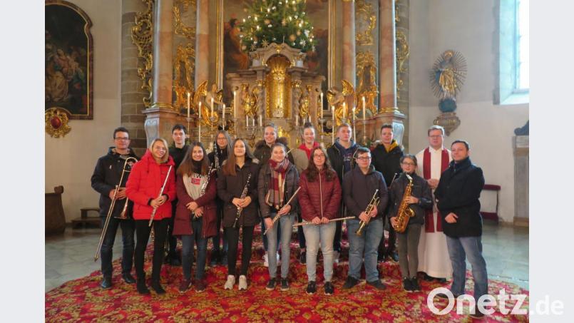Nach der Pfarrmesse bedankte sich Stadtpfarrer Thomas Kraus beim Kapellenleiter Renè Bauer (rechts) und den Musikanten der Kemnather Jugendblaskapelle. 
Die vier Holzbläser Theresa Haßmann, Nele Hassel, Paula Dimper und Alina Heining (vorne von links) verdienten ein Sonderlob. Bild: jzk