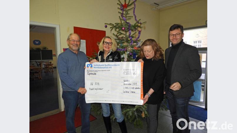 Der Lions-Club Weiden „Goldene Straße“ beschert 250 Flüchtlingskindern ein schönes Weihnachtsfest. Hierfür dankt Jost Hess vom AK Asyl (links) Präsidentin Andrea Schubert (Zweite von rechts) bei der symbolischen Scheckübergabe. Bild: Winkler