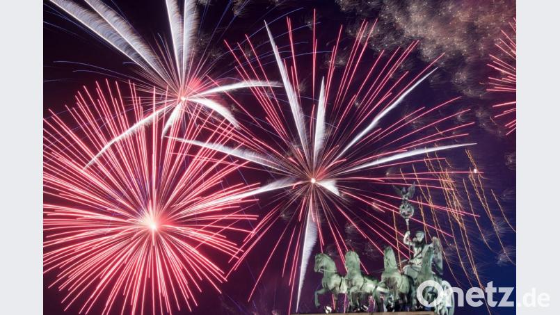 Ein Feuerwerk ist hinter dem Brandenburger Tor zu sehen. Foto: Ralf Hirschberger/dpa/Archiv Bild: Ralf Hirschberger