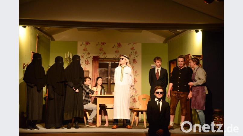 Der Scheich mit dem fast unaussprechlichen Namen hat drei "Haremsdamen" und seinen Leibwächter mitgebracht. Bauernsohn Kilian und Landratstochter Susi (im Hintergrund) hören aufmerksam der Geschichte des Scheichs zu, ebenso Bürgermeistergattin Rosaline, Bürgermeister Bartl Stanglmeier und der Herr Landrat (von rechts). Bild: bey