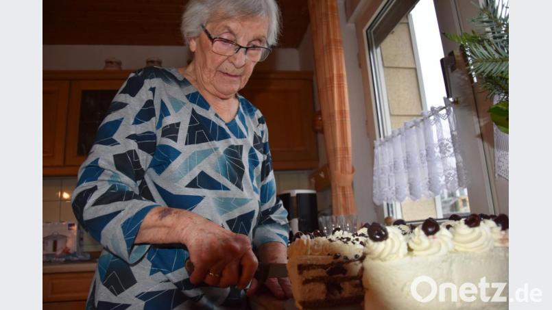 Erika Fuchs schneidet die Geburtstagstorte für ihre Gäste an. Bild: fuw