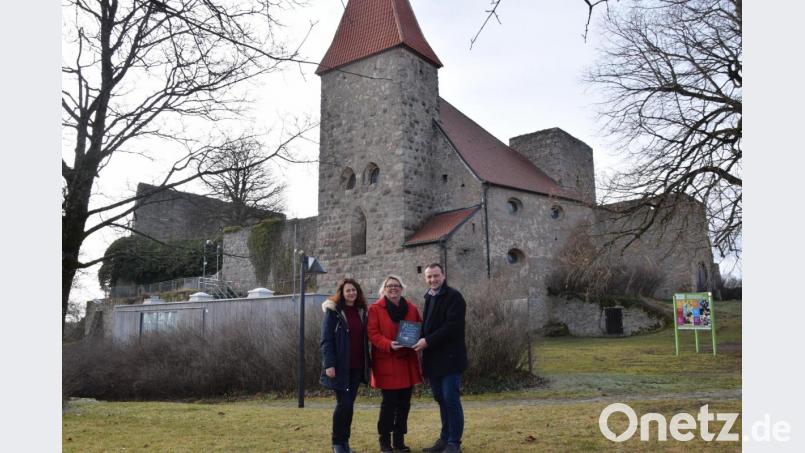 Autorin Gabriele Kiesl (links) und Lektorin Manuela Bonfissuto (rechts) übergeben Bürgermeister Anton Kappl auf der Burg das Buch &quot;Mystischen Burgen&quot;. Bild: fz