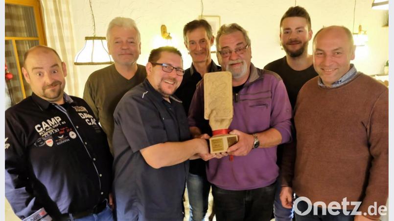 Der Sieger der Marktmeisterschaft, Andreas Sparrer, erhält den Wanderpokal vom Vorjahressieger Martin Ramhold überreicht. Organisatoren und Gewinner freuen sich gleichermaßen über den guten Verlauf des Schafkopfturniers. Bild: wlr