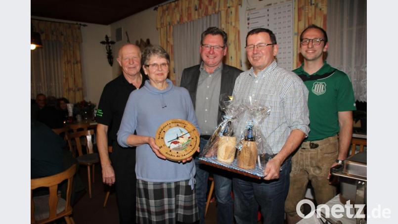 Die Wirtsleute Gertraud und Hans Winderl (vorne) sind von den Vereinen, die sie über Jahr-zehnte hinweg fürsorglich betreut haben mit zwei hölzernen Bierkrügen und einer Schießscheibe mit ihrem Haus darauf verabschiedet worden. Bild: frd