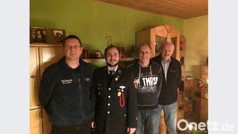 Klaus Sladky von der Blaskapelle, Tobias Schwamberger von der Feuerwehr(von links) sowie Georg Franz (Blaskapelle, rechts) gratulierten Peter Fischer zum 70. Geburtstag . Bild: rdh