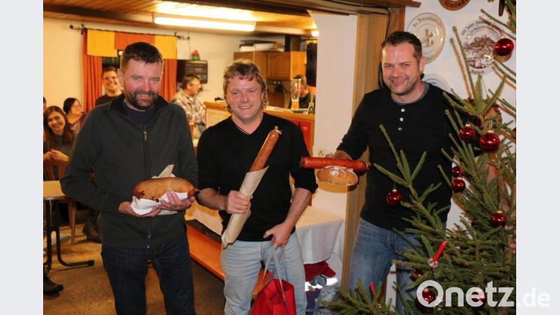Gerhard Bauer, Roland Rabenstein und Mario Bauer (von links) vom „Schwartenclub“ ersteigerten den Baumstamm und holten sichtlich stolz ihren „Einkauf“ ab. Sie hatten ihren „Fanclub“ dabei, so dass der riesige Presssack sicherlich bald verspeist sein wird. Bild: rpp