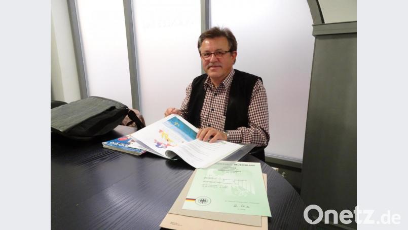 Konrad Schedl plädiert dafür, bei der erneuerbaren Energie auch vermehrt auf schwimmende Windräder zu setzen. Vor ihm liegt das Gebrauchsmuster für „Auftriebskörper für schwimmende und halbschwimmende Windparks“, das er 2001 eingereicht hat. Bild: rti