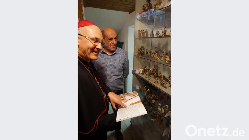 Ein gut gelaunter Bischof Rudolf mit Michael Elsner vor dessen Ausstellungsvitrine mit einer großen Auswahl an Krippenfiguren. Bild: wec