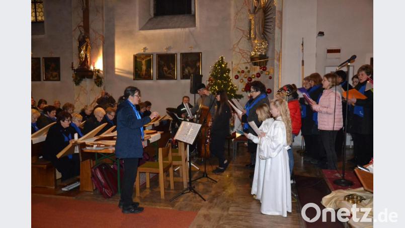 Die Veeh-Harfen, Sängerinnen und Kinderchor singen gemeinsam Weihnachtslieder begleitet von Schlagzeug und Bass unter der Leitung von Petra Zielbauer. Bild: gi