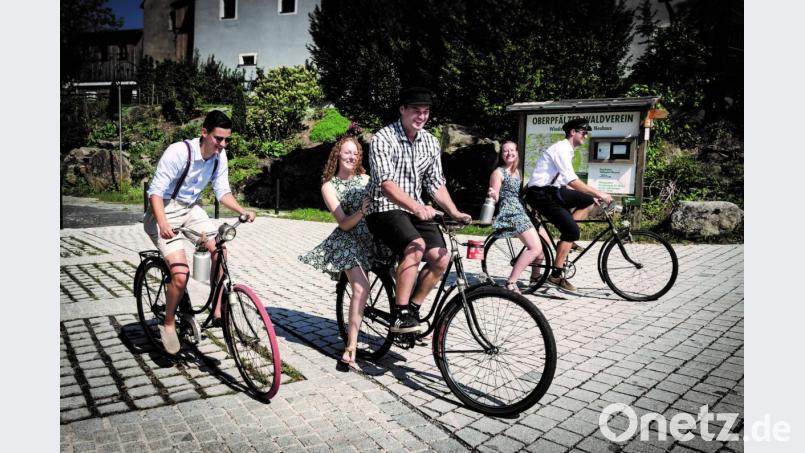 Das Juli-Blatt aus dem Kalender: Simon Windschiegl, Jonas und David Kreinhöfner radeln auf historischen Fahrrädern im Neuhauser Burghof. Auf dem Gepäckträger sitzen Magdalena Windschiegl und Christina Herrmann. Bild: exb