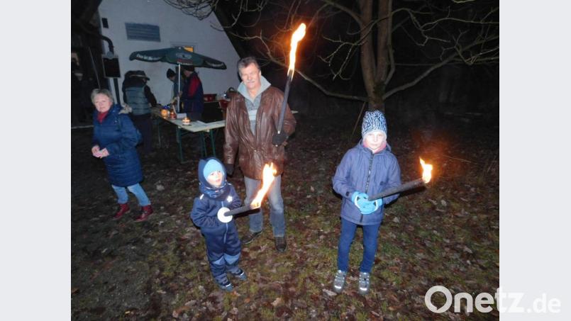 Mit ihren Fackeln warteten die Kinder auf das Entzünden des Holzstoßes. Bild: hai