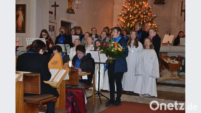 Zum Abschluss des Weihnachtskonzerts singen alle das „Stille Nacht“. Für die Leiterin Petra Zielbauer gibt es einen Blumenstrauß. Bild: gi