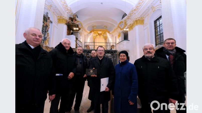 Kirchenpfleger Josef Beer (Fünfter von links) zeigt die Bronzeplakette, die auf die Förderung der Sanierung durch die Deutsche Stiftung Denkmalschutz und die Glücksspirale hinweist. Darüber, dass die Arbeiten bald abgeschlossen sind, freuen sich (von links) Pfarrer Herbert Grosser, Gerd Sommer (Deutsche Stiftung Denkmalschutz), Architekt Michael Dittmann, Erich Meidinger (Kirchenverwaltung), Ortsheimatpflegerin Christine Schormüller, Hermann Sturm (Kirchenverwaltung) und Bürgermeister Josef Gilch. Bild: Stephan Huber