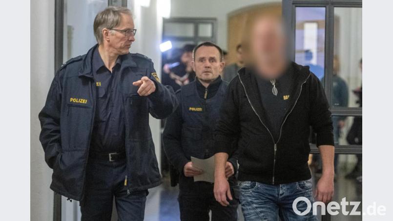 Der Angeklagte (r) geht neben zwei Polizisten in den Verhandlungssaal des Landgerichts. Bild: Armin Weigel/dpa