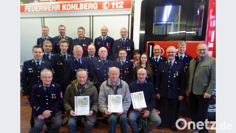 Langjährige Feuerwehrmitglieder und die Führungsmannschaft präsentieren sich am Löschfahrzeug um den neuen Kommandant Matthias List (Zweite Reihe, links) und die beiden Stellvertreter Dominik Zwack und Johannes Kummer (hinten, Zweiter und Dritter von links). Bild: jml