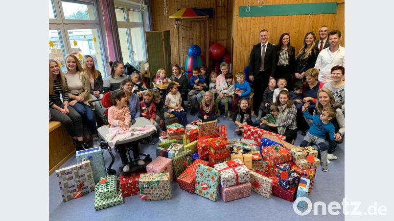 Filialdirektor Christian Wolf (hintere Reihe, Fünfter von rechts) übergibt mit einigen Mitarbeitern die Geschenke an die Kindergartenkinder des HPZ Irchenrieth. Bild: exb