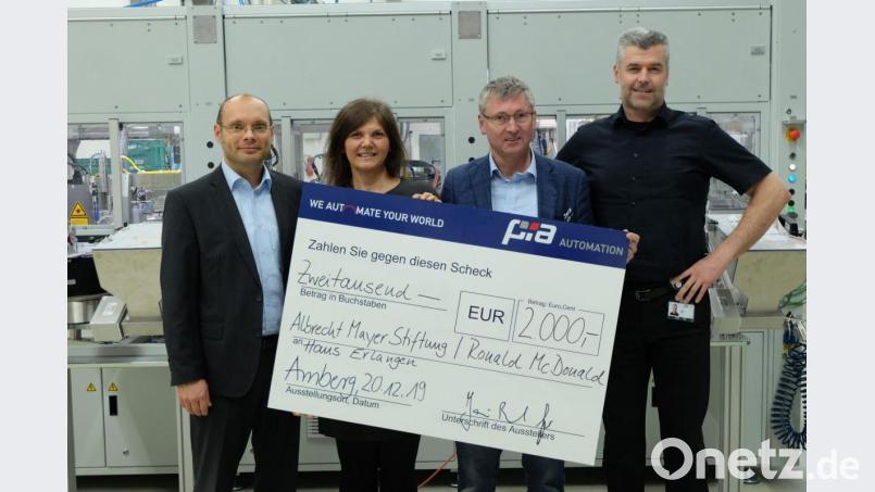 Jan-Bernd Gier (links) und André Vales (rechts), die Geschäftsführer der PIA Automation, übergeben den Scheck an Heike Weber vom Ronald-McDonald-Haus Erlangen und Franz Badura von der Albrecht-Mayer-Stiftung. Bild: PIA Automation Amberg/exb
