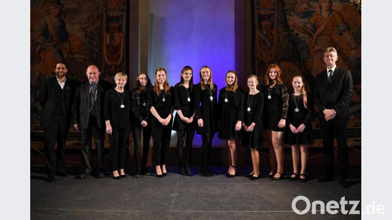 Von links: Ironman-Weltmeister Faris Al-Sultan, Schulleiter OStD Georg Hecht, Sportlehrerin Maria Dürrschmidt, Annika Brech, Lena Rath, Kathrin Bachmeier, Viktoria Bogner, Daria Codlova, Marlene Züllich, Daniela Codlova, Dominika Codlova, Kultusminister Michael Piazolo. Bild: Andreas Gebert, StMWK/exb