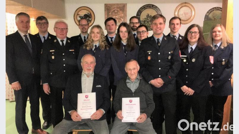 Vorsitzender Florian Plödt (Vierter von rechts) mit den geehrten und beförderten Feuerwehrmännern. Neuer Ehrenvorstand Gerhard Weidner (vorne, links) und Herrmann Eckert (vorne, rechts) der für 70 Jahre Mitgliedschaft geehrt wurde. Dahinter die neuen Mitglieder der Jungfeuerwehr, Emilie Hacker und Nina Hößl, die ihre Dienstbücher erhielten. Von links: Bürgermeister Thomas Meiler, Kommandant Hettler und Kreisbrandmeister Alfons Huber. Bild: cro