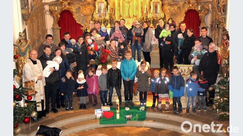 Elf Täuflinge und ihre Eltern versammelten sich zur Erinnerung an die Taufe im Jahr 2019 am Altar. Auch viele Geschwister waren mit dabei und so herrschte reges Leben während der Andacht mit Pfarrer Herbert Rösl (links) und Pastoralreferent Andreas Hartung (rechts) in der Pfarrkirche. Bild: boj