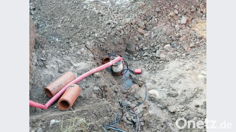 Eine Pumpe befördert das Wasser aus der Grube, damit die Bauhof-Mitarbeiter nach dem Leck suchen können. Bild: anv