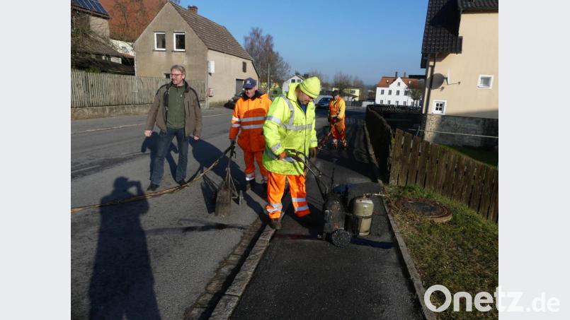 Straßensanierung in Eschenbach: Nach Reinigung der Fahrbahnrisse mit der Heissluftlanze (links) werden sie mit flüssiger Bitumenmasse ausgegossen (rechts). Bild: rn