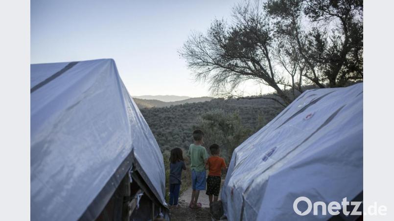 Drei Kinder stehen zwischen Zelten in einem provisorischen Lager neben dem Flüchtlingslager von Moria. Bild: Socrates Baltagiannis/dpa