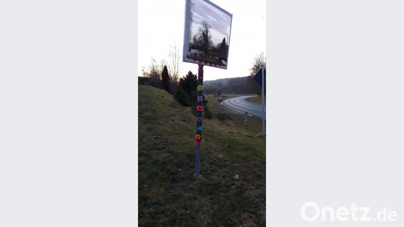 Blümchen am Pfosten eines Verkehrsspiegels sind ein weiteres Beispiel für Urban Knitting. Bild: alr