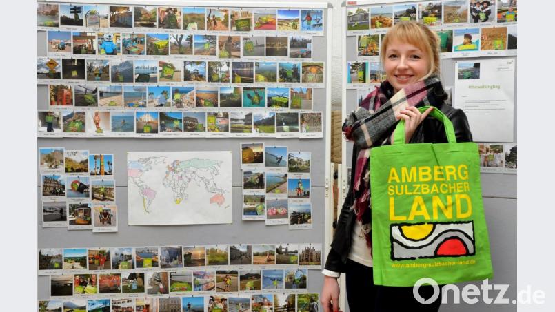 Regina Wolfohr, Tourismus-Fachkraft am Landratsamt, sammelt die Bilder der um die Welt reisenden grünen Tasche nicht nur im Internet, sondern auch an Stellwänden im Foyer des Landratsamts in Amberg. Bild: Stephan Huber