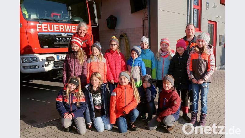 Schule einmal anders: Lehrerin Claudia Wölke (hinten links) war mit ihrer Klasse zu Gast bei der Feuerwehr. Zum Unterricht steuerten Feuerwehrmitglieder wichtige Informationen bei. Zweiter Kommandant Jürgen Schultes (hinten rechts) brachte die Kinder abschließend mit dem Feuerwehrauto zurück zur Schule. Bild: bsc
