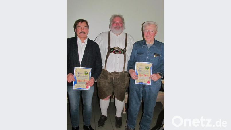 Die neuen Ehrenmitglieder der &quot;Waldlust“-Schützen sind Bernd Fischer (links) und Peter Bumke (rechts). Schützenmeister Markus Merkl überreicht ihnen die Urkunde. Bild: is