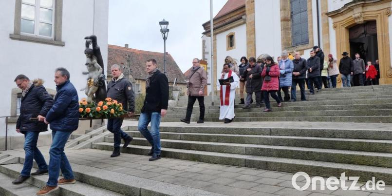 Vier Männer tragen die geschmückte Statue des heiligen Sebastian in einer Prozession durch die Straßen der Stadt Vilseck. Bild: rha