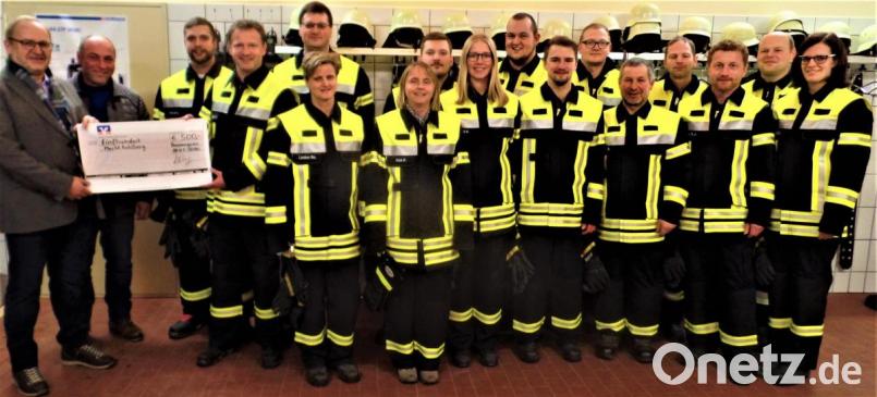 Freude bei den Löschgruppen der Hannersgrüner Feuerwehr! Mit den neuen Schutzanzügen sind sie bestens ausgerüstet, wie Kommandant Alexander Krauß (Dritter von links) zufrieden feststellt. Vorstand Manfred Häring (rechts daneben) übergibt als Zuschuss vom „Dörferer“ Feuerwehrverein einen Scheck über 500 Euro an die Bürgermeister Rudolf Götz und Gerhard List (von links). Bild: jml