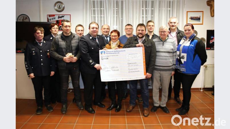 Feuerwehrvorsitzender Matthias Reul (Fünfter von links) und Andreas Schaumberger (Fünfter von rechts) überreichten den Spendenscheck über 2500 Euro an die Schirmherrin der Aktion &quot;Lichtblicke&quot;, Edith Lippert (Siebte von links). Mit auf dem Bild unter anderem Bürgermeister Uli Roth (Zweiter von rechts), Zweiter Bürgermeister Reinhard Naber (Dritter von rechts) sowie Bäckermeister Manuel Neugirg (Dritter von links). Bild: njn