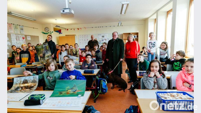 Rektorun Gabriele Moser (stehend, rechts) und Lehrerin Julia Butz (stehens, links) freuten sich mit den Kindern der Ettmannsdorfer Grundschule über die Kalender, die der Vorsitzende des Jägervereins St. Hubertus, Johann Vornlocher (stehend, Zweiter von rechts) und Ehrenvorsitzender Herbert Krauthann (stehend, Dritter von rechts) übergaben. Bild: Hösamer