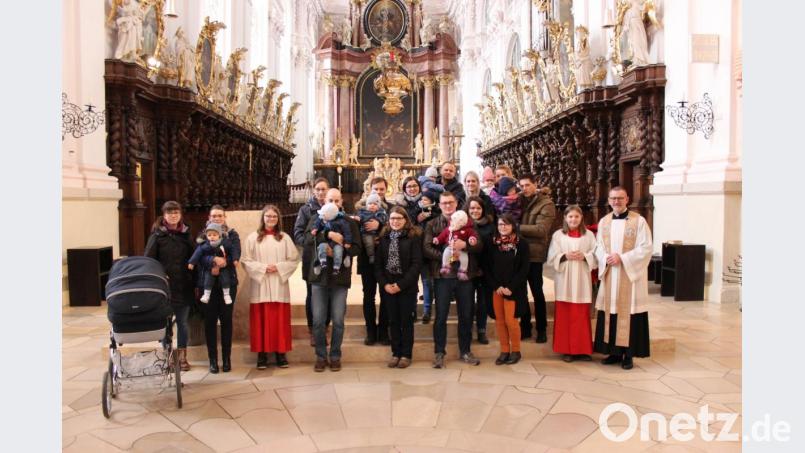 Stadtpfarrer Thomas Vogl (rechts) mit den Eltern und ihren Kindern beim Tauferinnerungsfest in der Basilika Waldsassen. Bild: exb