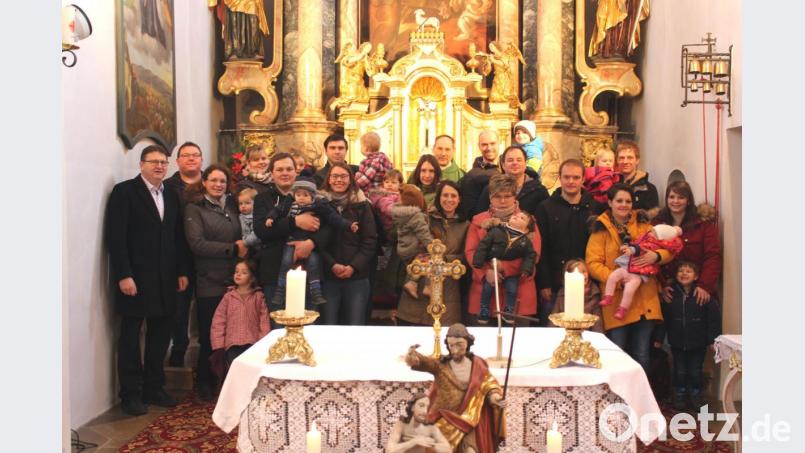 Pfarrer Gerhard Wagner (Bildmitte) und Pfarrgemeinderatsvorsitzender Werner Schönberger (links) begrüßten in der Pfarrkirche die Täuflinge der Jahre 2018 und 2019 der Pfarrei Rottendorf mit ihren Eltern und Geschwistern. Bild: exb