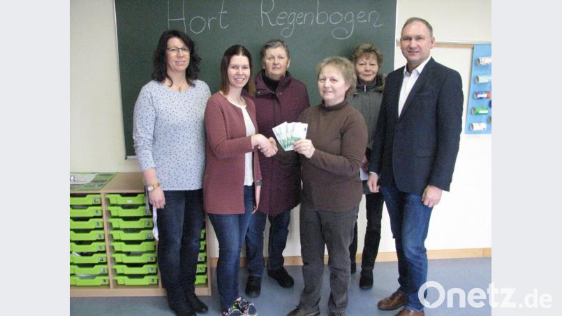 Kunigunde Schleyer, Christine Härtl und Roswitha Schmidt (Fünfte bis Dritte von links) und übergeben den Gewinn der Weihnachtstombola an Susanne Zimmermann, Leiterin des Kinderhorts „Regenbogen“. Auch Kinderhausleiterin Doris Weigl (links) und Bürgermeister Richard Kammerer (rechts) freuen sich. Bild: knh