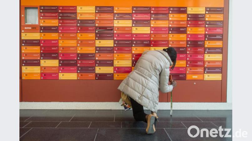 Eine Frau öffnet ihren Briefkasten. Gibt es in Amberg Bedarf für das Projekt "Wohnen für Hilfe"? Archivbild: Matthias Balk