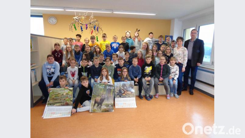 Die Schüler der dritten und vierten Klasse mit den Lehrern Annemarie Mösbauer (hinten, Dritte von rechts) und Kurt Pöll (hinten, Fünfter von rechts) freuten sich über die Jagdkalender, den (von rechts) Alexander Flierl, Bürgermeisterin Sonja Meier und Rainer Mösbauer überreichten. Bild: amö