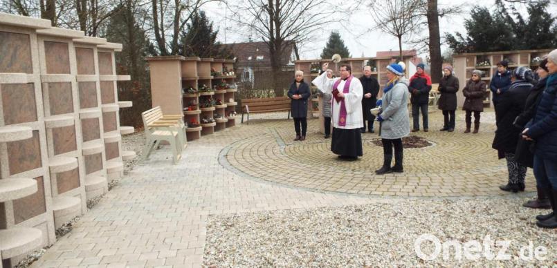 Pfarrer Klaus Haußmann segnet die neue Urnenwand mit insgesamt 20 Kammern. Daneben stehen barrierefrei zu erreichende Sitzbänke. Bild: e