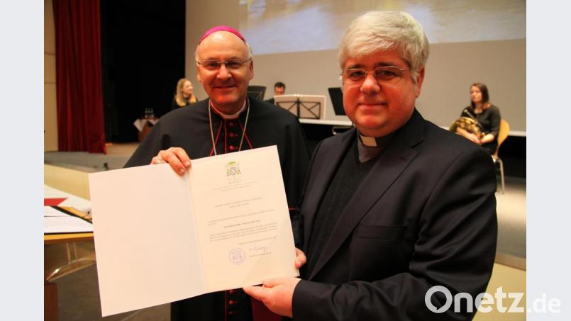 Bischof Rudolf Voderholzer übergibt Dekan Pfarrer Thomas Jeschner die Ernennungsurkunde zum Bischöflichen Geistlichen Rat. Bild: exb
